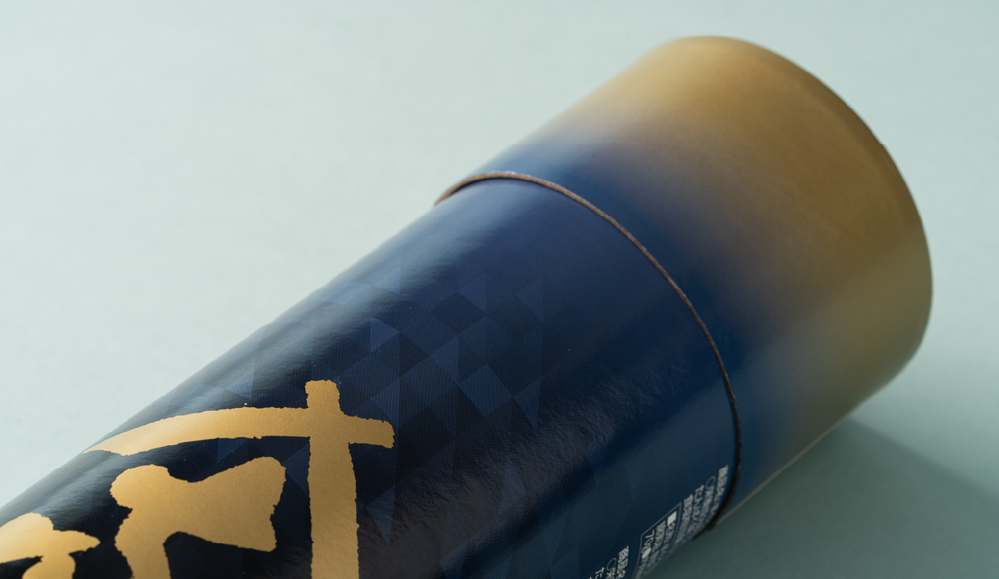 紺から金へグラデーションが施された紙管パッケージのデザイン